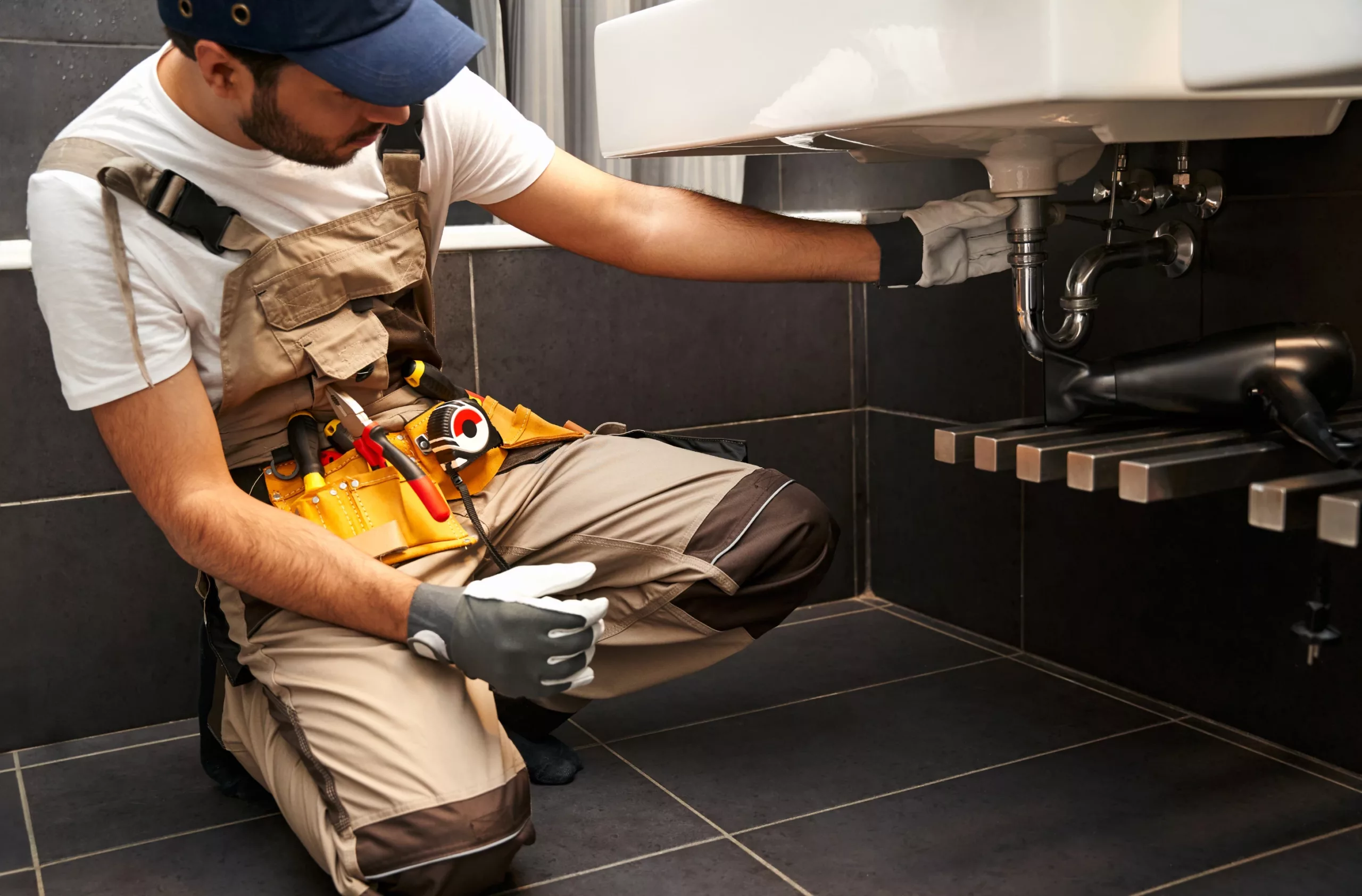 Professional plumber repairing bathroom sink